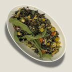 Infusion de plantes bio Équilibre intérieur en vrac dans une coupelle blanche : longues feuilles de verveine, fleurs de camomille, graines de fenouil et morceaux de carotte