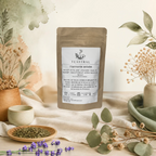 Sachet kraft de l'infusion bio Harmonie anisée Teastral, posé sur un lin beige avec eucalyptus, lavande et coupelle de plantes séchées