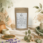 Sachet kraft de l'infusion de rooibos bio Velours rubis Teastral, posé sur un lin beige avec eucalyptus, lavande et coupelle de plantes séchées