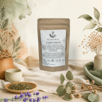 Sachet kraft du mélange de thé noir et thé vert bio Évasion tropicale Teastral, posé sur un lin beige avec eucalyptus, lavande et coupelle de plantes séchées