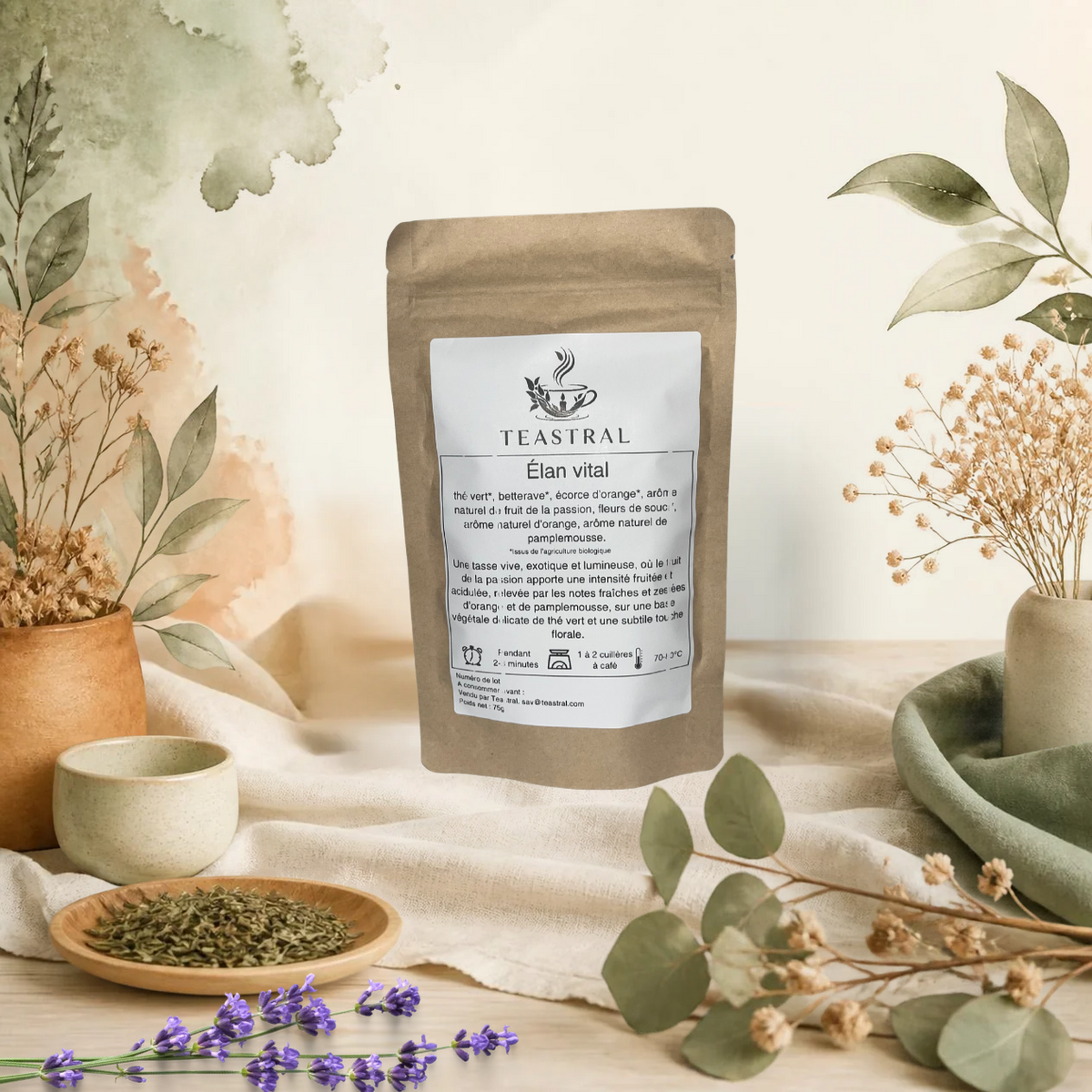 Sachet kraft du thé vert bio Élan vital Teastral, posé sur un lin beige avec eucalyptus, lavande et coupelle de plantes séchées