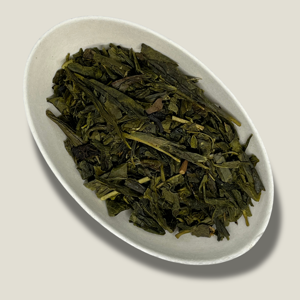Feuilles de thé vert Sencha bio aromatisé à la bergamote en vrac dans une coupelle blanche
