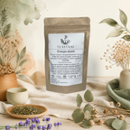 Sachet kraft du thé vert Sencha bio Énergie douce Teastral, posé sur un lin beige avec eucalyptus, lavande et coupelle de plantes séchées