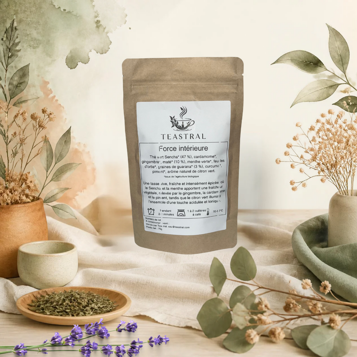 Sachet kraft du thé vert Sencha bio Force intérieure Teastral, posé sur un lin beige avec eucalyptus, lavande et coupelle de plantes séchées